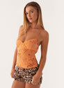 Orange sequin floral cami top, three-quarter front view on model