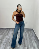 Burgundy criss-cross halter top with jeans, full length front view