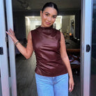 Burgundy faux-leather ruched top styled with jeans, front view on model