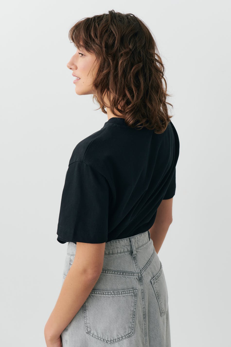 Black cotton crew neck t-shirt, back view on model