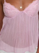 Close-up of the pink lace bust detail on the pleated top