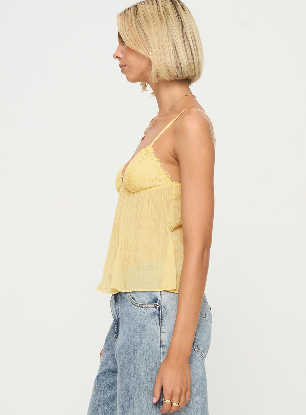 Yellow lace pleated cami top, side view on model