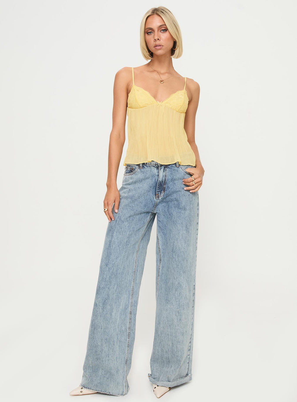 Yellow lace pleated cami top with jeans, front view on model