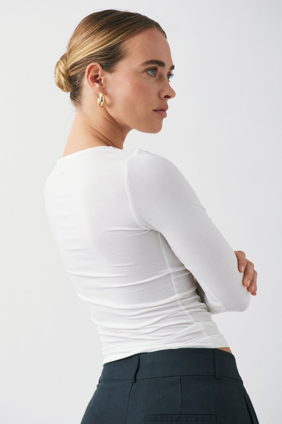 White fitted long sleeve top, back view on model