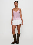 Pink lace cami top with white skirt, full length on model