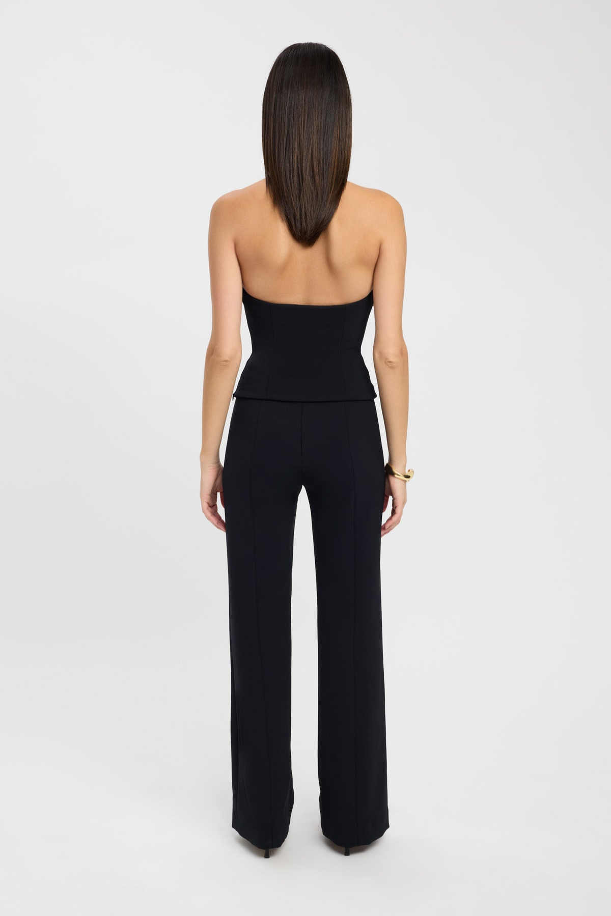 Black strapless bustier top, back view styled with trousers