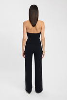 Black strapless bustier top, back view styled with trousers