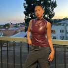 Burgundy faux-leather sleeveless top, outdoor front view on model