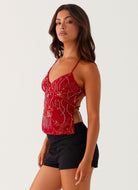 Red sequin floral cami top, side view on model