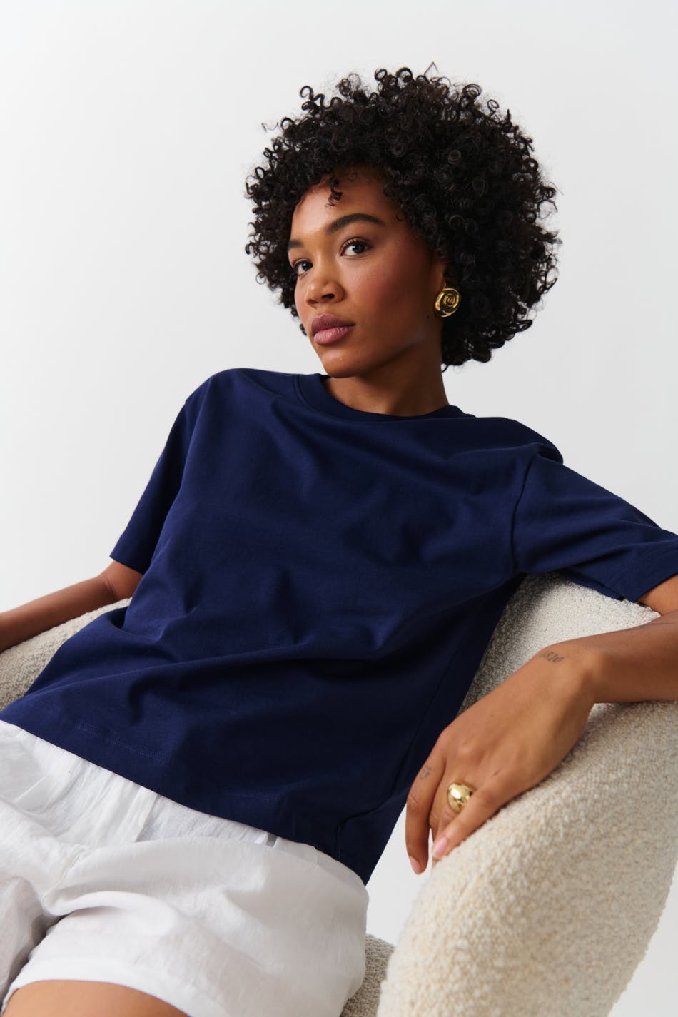 Deep navy cotton crew neck t-shirt, seated pose on model
